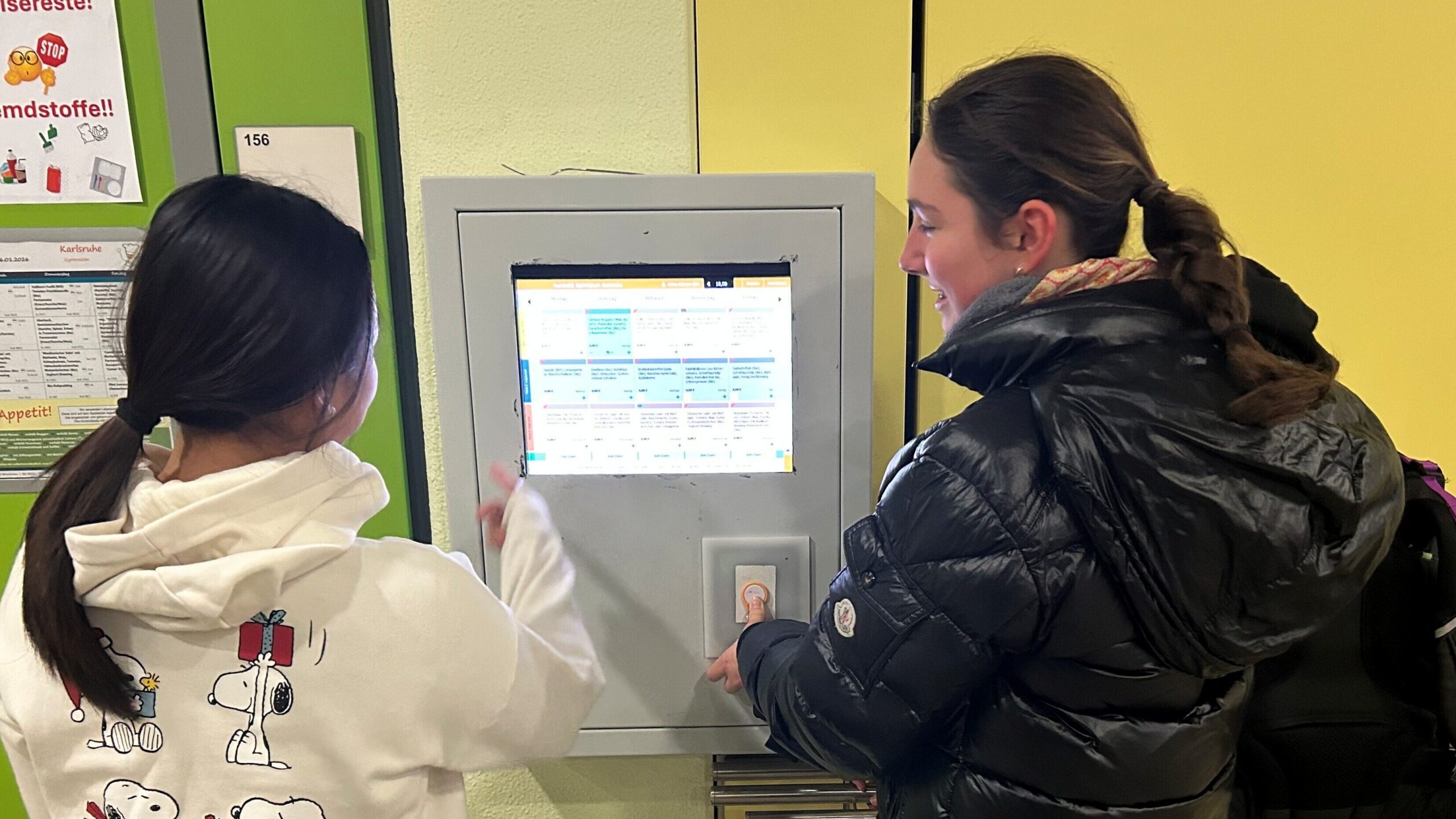 Zwei Schülerinnen benutzen den Buchungsautomaten für die HGK-Mensa.