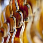Symbolbild: mehrere Violinenkorpusse hintereinander mit starker Tiefenunschärfe